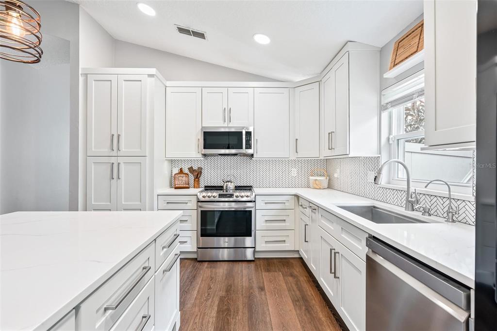 325 Longshadows Court Ocoee, FL 34761 - Photo 8 of 34 a kitchen with a sink white cabinets and stainless steel appliances