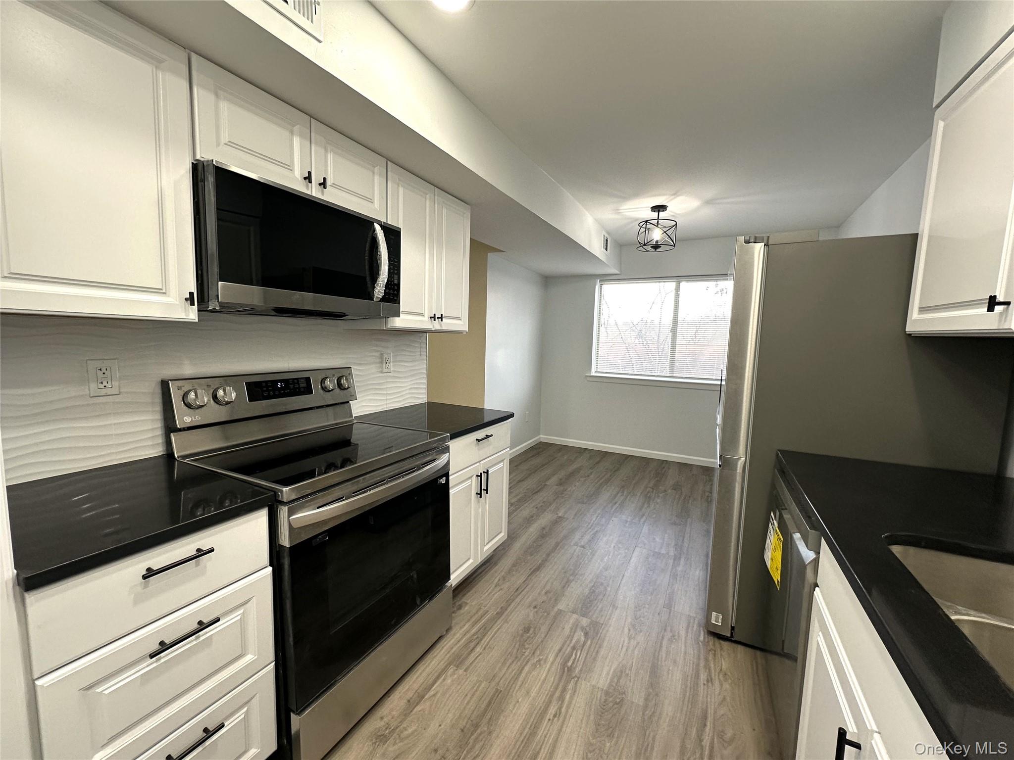 26 Cooper, Unit 511 Poughkeepsie, NY 12603 - Photo 2 of 15 a kitchen with stainless steel appliances a stove microwave and sink