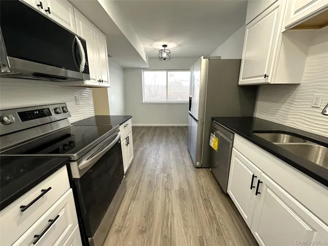 a kitchen with stainless steel appliances a stove microwave and sink
