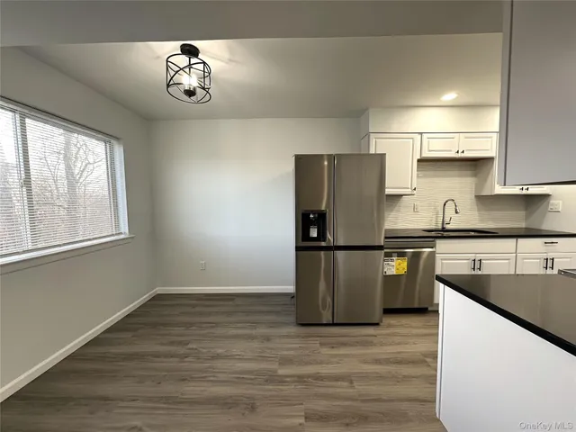 a kitchen with granite countertop a sink a stove and refrigerator