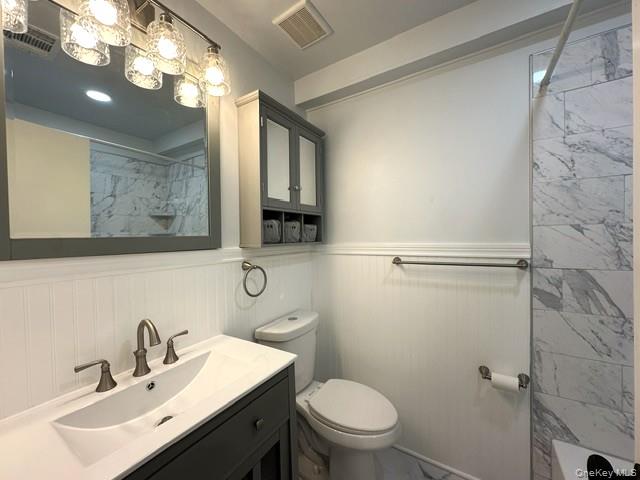 26 Cooper, Unit 511 Poughkeepsie, NY 12603 - Photo 8 of 15 a bathroom with a sink vanity mirror and toilet