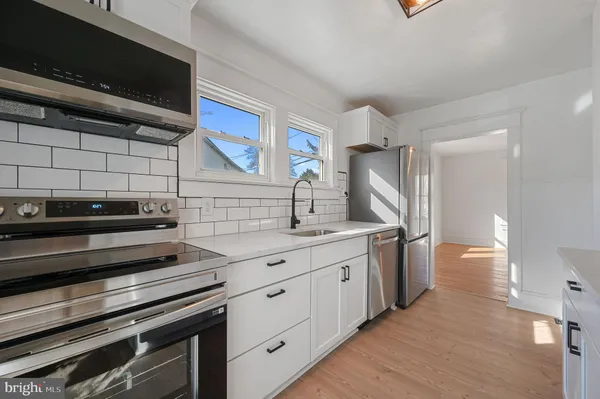 a kitchen with stainless steel appliances a stove a sink and a microwave