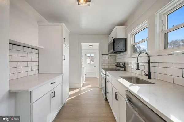 a large kitchen with a sink and a refrigerator