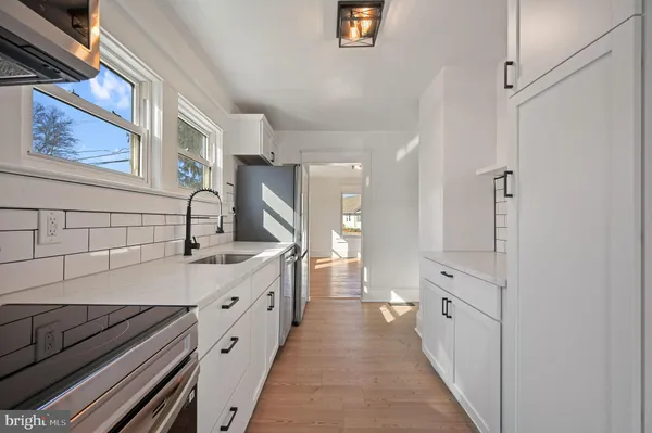 a kitchen with white cabinets and sink