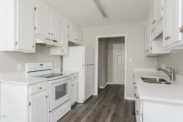 a kitchen with white cabinets and white appliances