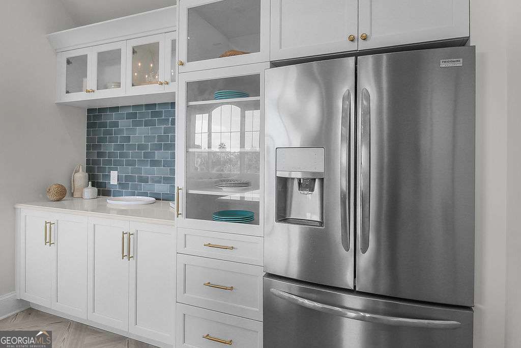 20 Taylor Street Tybee Island, GA 31328 - Photo 52 of 85 a kitchen with white cabinets and stainless steel appliances
