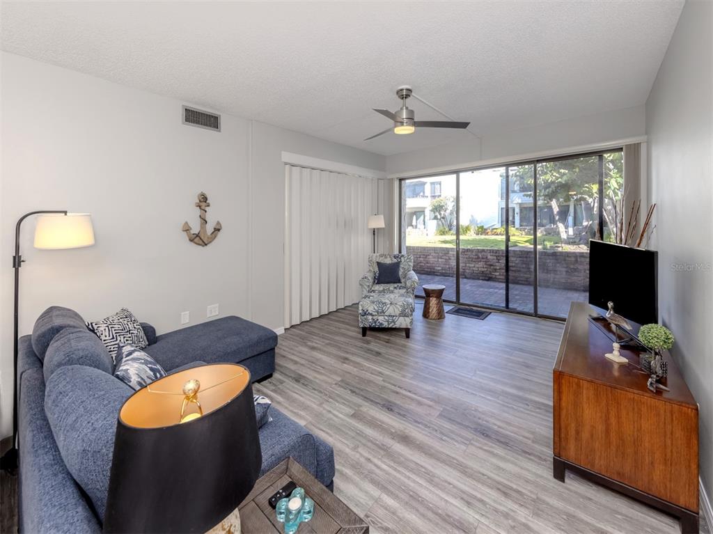 1555 Tarpon Center Drive, Unit 140 Venice, FL 34285 - Photo 16 of 60 a living room with furniture and a flat screen tv
