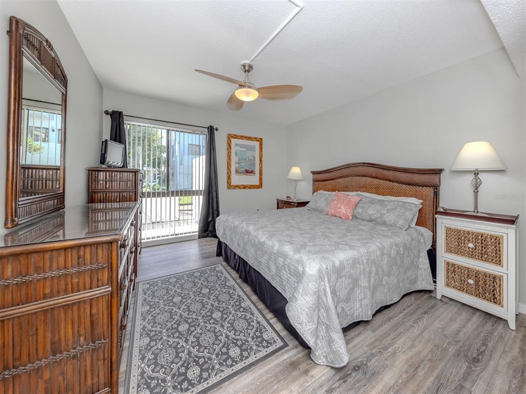 1555 Tarpon Center Drive, Unit 140 Venice, FL 34285 - Photo 19 of 60 a bedroom with a large bed and a chandelier