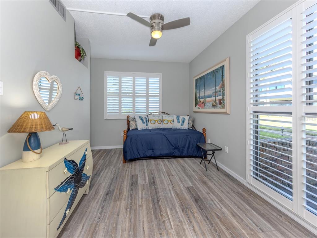 1555 Tarpon Center Drive, Unit 140 Venice, FL 34285 - Photo 22 of 60 a bedroom with a bed and wooden floor
