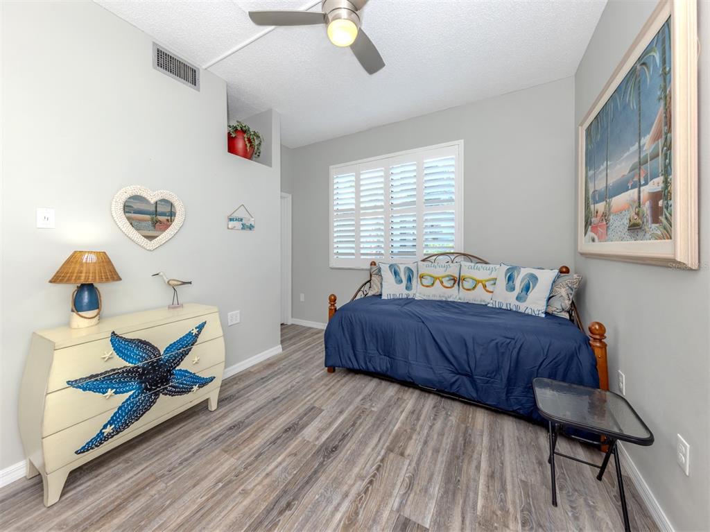 1555 Tarpon Center Drive, Unit 140 Venice, FL 34285 - Photo 23 of 60 a bedroom with a bed and wooden floor