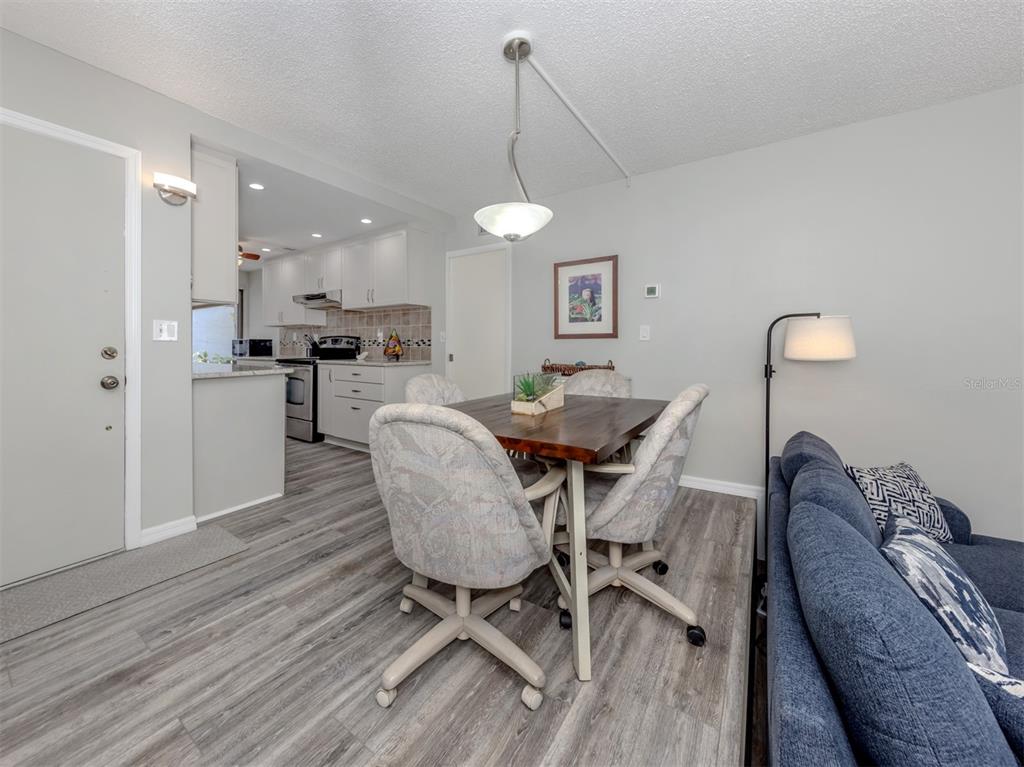 1555 Tarpon Center Drive, Unit 140 Venice, FL 34285 - Photo 3 of 60 a view of a dining room with furniture wooden floor and chandelier