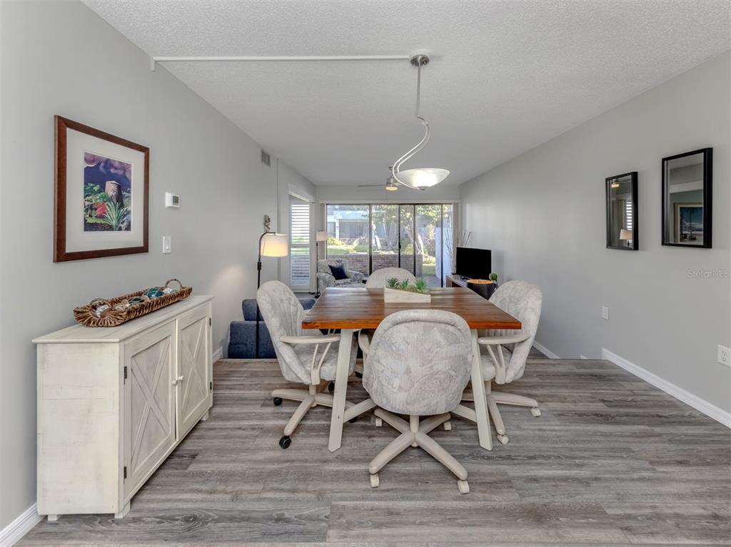 1555 Tarpon Center Drive, Unit 140 Venice, FL 34285 - Photo 5 of 60 a view of a dining room with furniture window and wooden floor