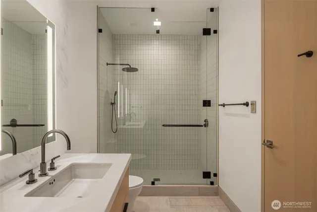 a bathroom with a sink a toilet and shower