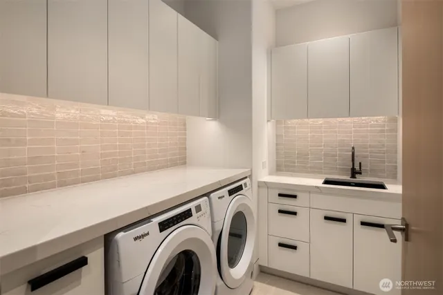 a view of washer and dryer with kitchen in the background
