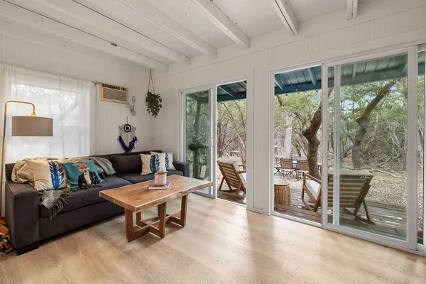 a living room with furniture wooden floor and a large window