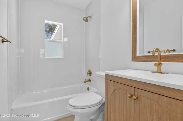 a bathroom with a sink toilet vanity and tub
