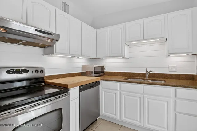 a kitchen with granite countertop a sink stainless steel appliances and cabinets