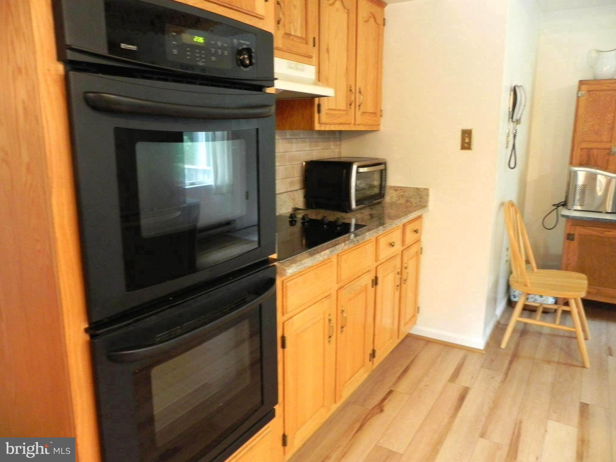 4285 Glory Road Bealeton, VA 22712 - Photo 27 of 76 a kitchen with granite countertop wooden cabinets a stove and a sink