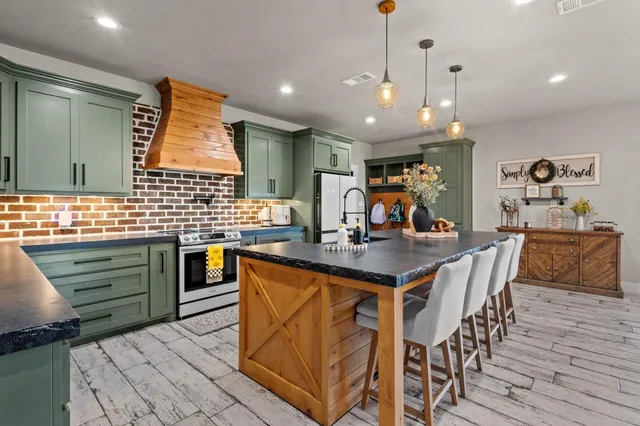 a kitchen with stainless steel appliances kitchen island granite countertop a sink and cabinets