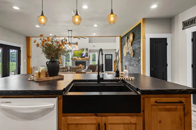 a kitchen with stainless steel appliances granite countertop a sink a stove and a granite counter top