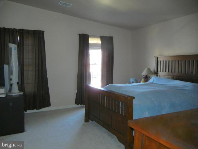 6568 Forsythia Street Springfield, VA 22150 - Photo 11 of 15 a bedroom with a bed and a window