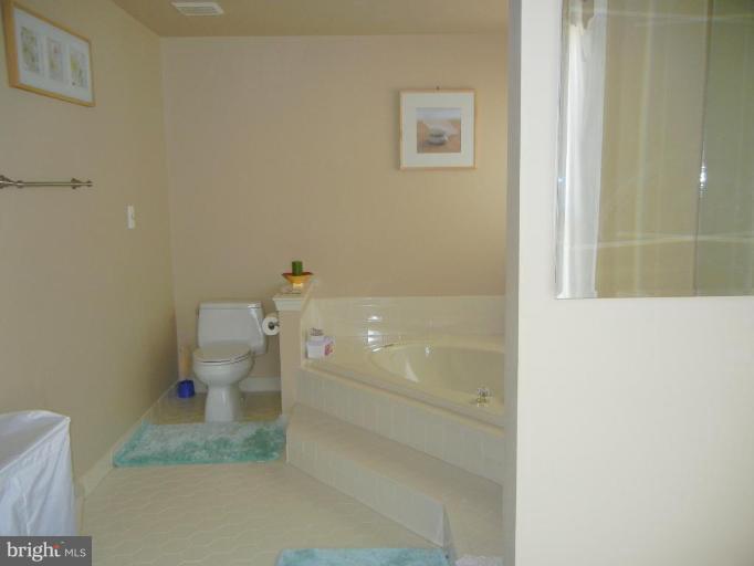 6568 Forsythia Street Springfield, VA 22150 - Photo 12 of 15 a bathroom with a granite countertop toilet and a shower