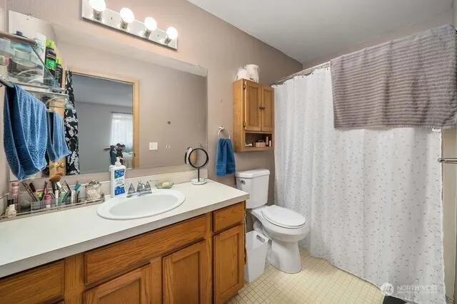 a bathroom with a double vanity sink toilet and a mirror