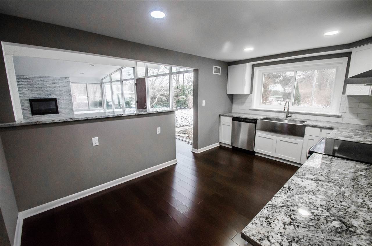 3209 North View Road Rockford, IL 61107 - Photo 12 of 25 a large kitchen with stainless steel appliances a large window a stove and a wooden floors
