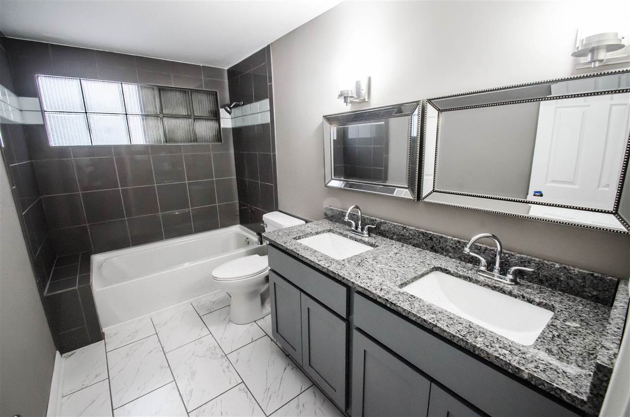3209 North View Road Rockford, IL 61107 - Photo 15 of 25 a bathroom with a granite countertop sink a mirror and a bathtub