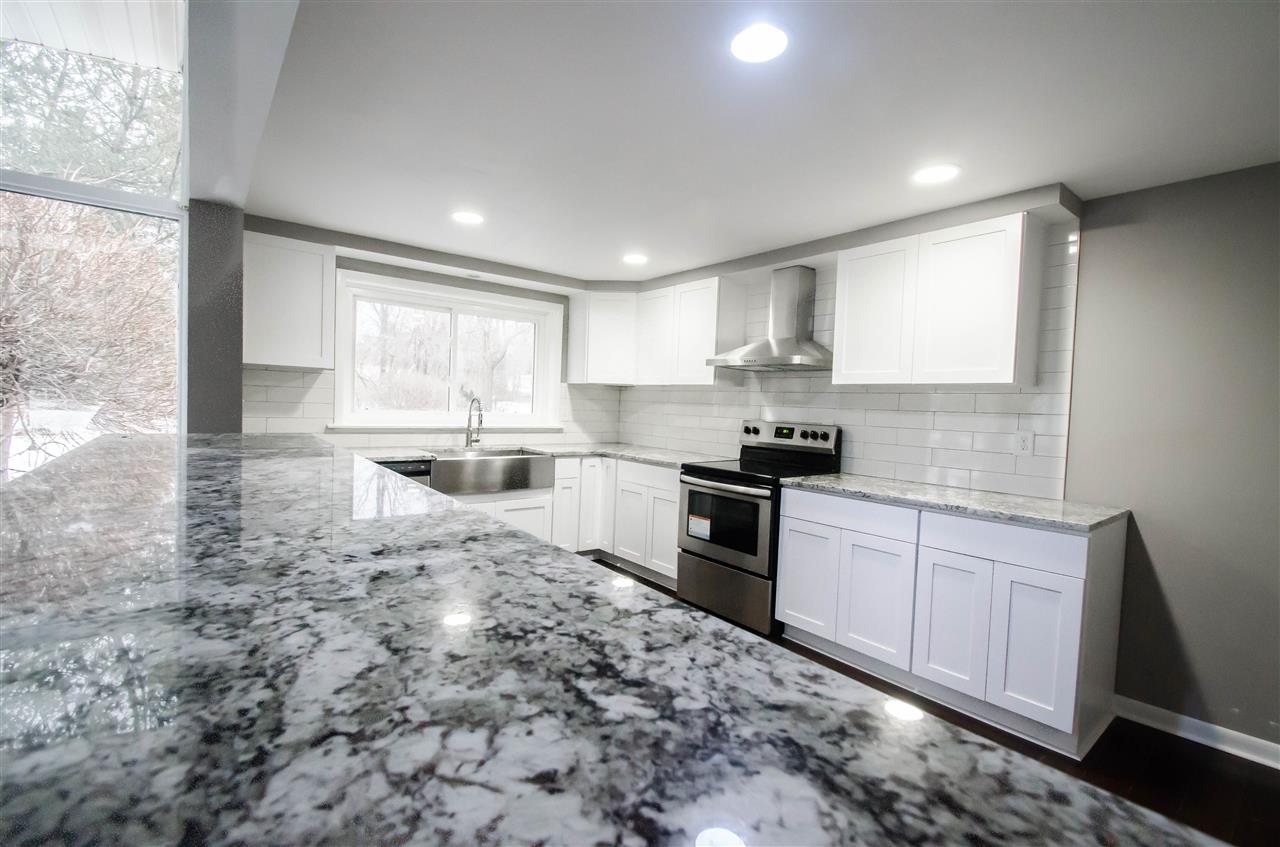 3209 North View Road Rockford, IL 61107 - Photo 9 of 25 a kitchen with granite countertop a stove a sink and a microwave