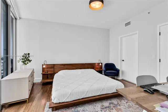 a bedroom with a bed and a potted plant