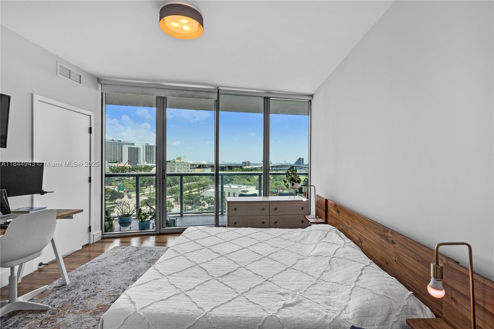 888 Biscayne Boulevard, Unit 812 Miami, FL 33132 - Photo 13 of 36 a bed sitting in a bedroom next to a window