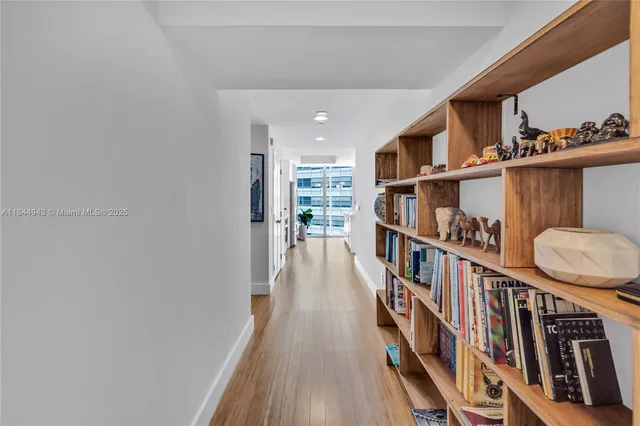 a hallway with wooden floor and book shelf