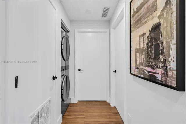 a view of a hallway with wooden floor and closet