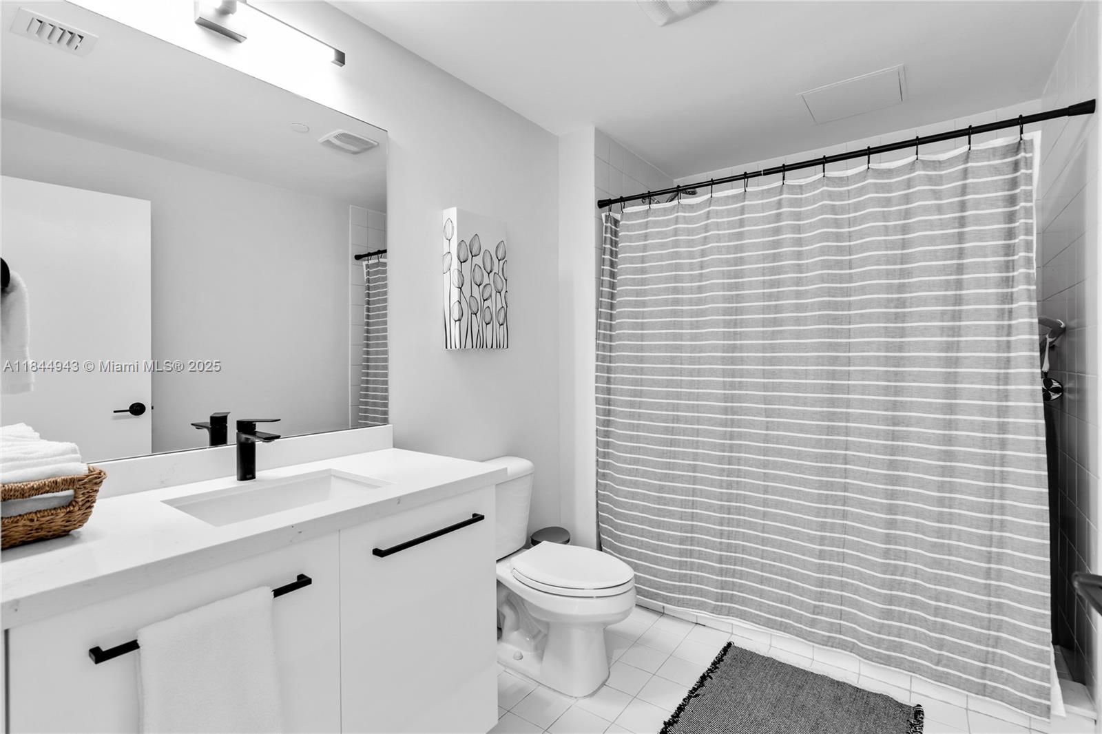 888 Biscayne Boulevard, Unit 812 Miami, FL 33132 - Photo 23 of 36 a bathroom with a sink a toilet and shower curtain