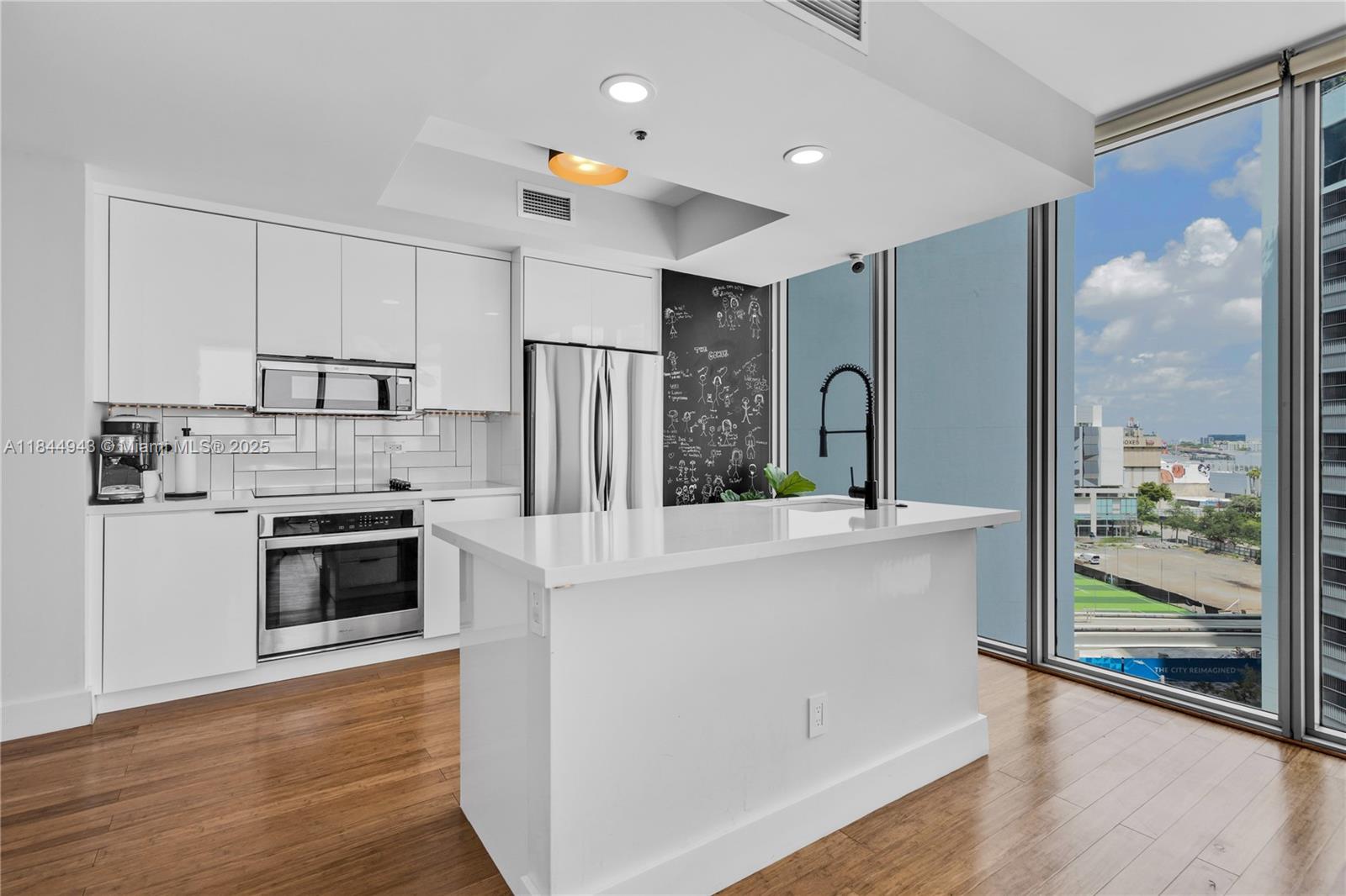 888 Biscayne Boulevard, Unit 812 Miami, FL 33132 - Photo 9 of 36 a kitchen with stainless steel appliances a refrigerator and a stove top oven