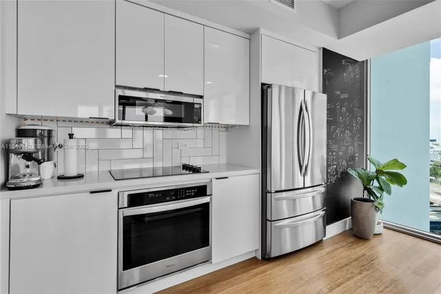 a kitchen with appliances a refrigerator and wooden floor