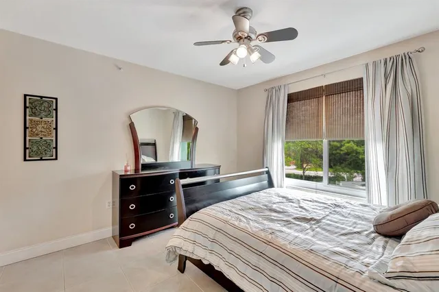 a bedroom with a bed dresser and window