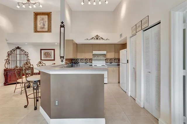 a kitchen with kitchen island a counter top space a sink stainless steel appliances and cabinets