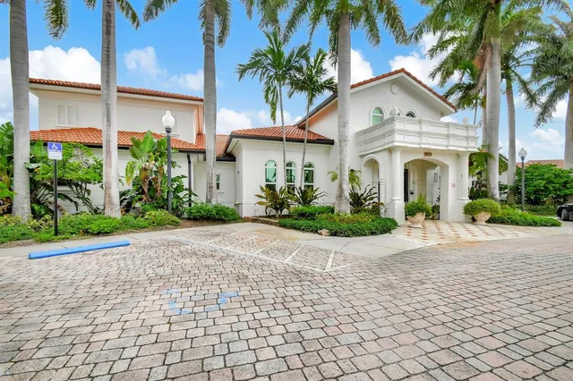a view of a white house with a large windows and flower plants