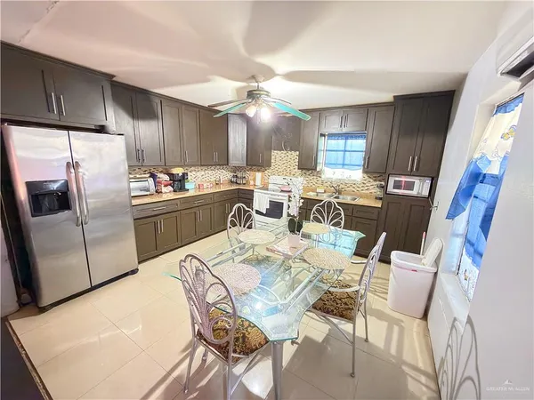 a view of a dining room with furniture a kitchen and chandelier