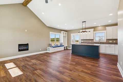 a large kitchen with stainless steel appliances kitchen island a large counter top and wooden floors