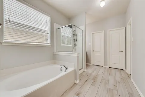 a bathroom with a bathtub and a window
