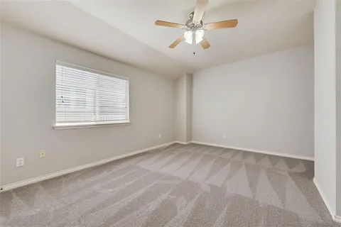 an empty room with a window and a fan