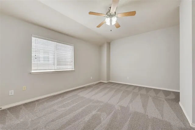 an empty room with a window and a fan