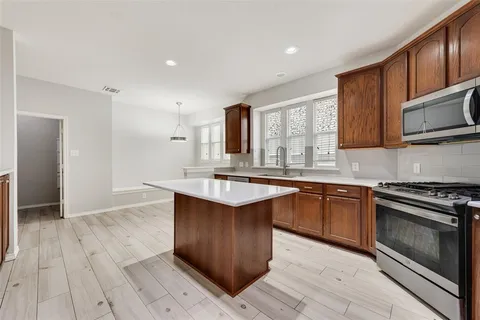 a kitchen with stainless steel appliances granite countertop a stove a sink and a microwave