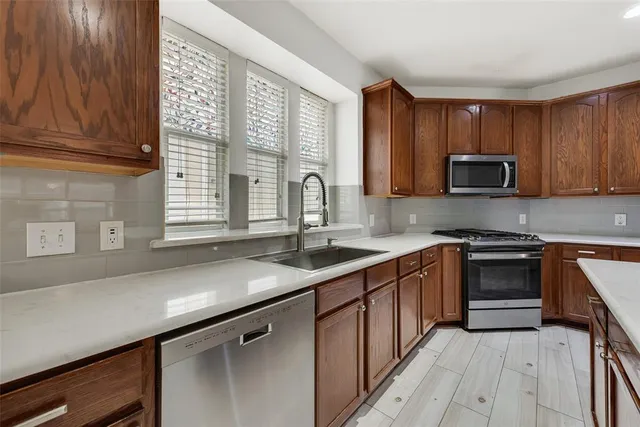 a kitchen with granite countertop a sink stove and cabinets