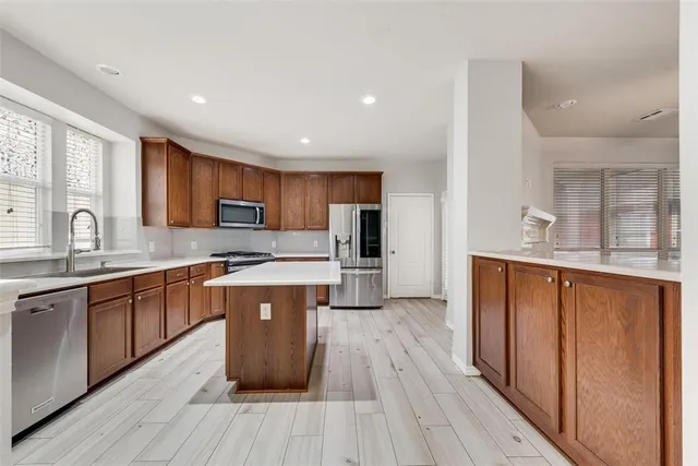 a large kitchen with wooden floors and stainless steel appliances