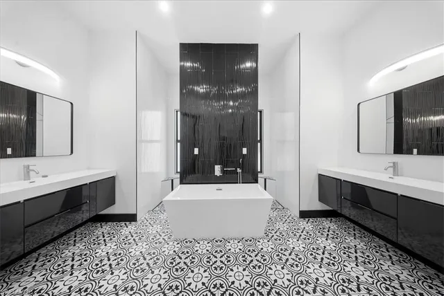 a bathroom with a sink a large mirror and a bathtub