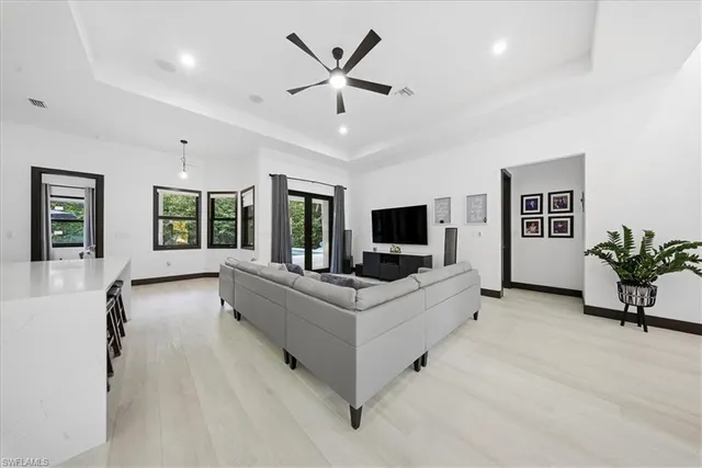 a kitchen with stainless steel appliances granite countertop a refrigerator a sink a stove and a wooden floors